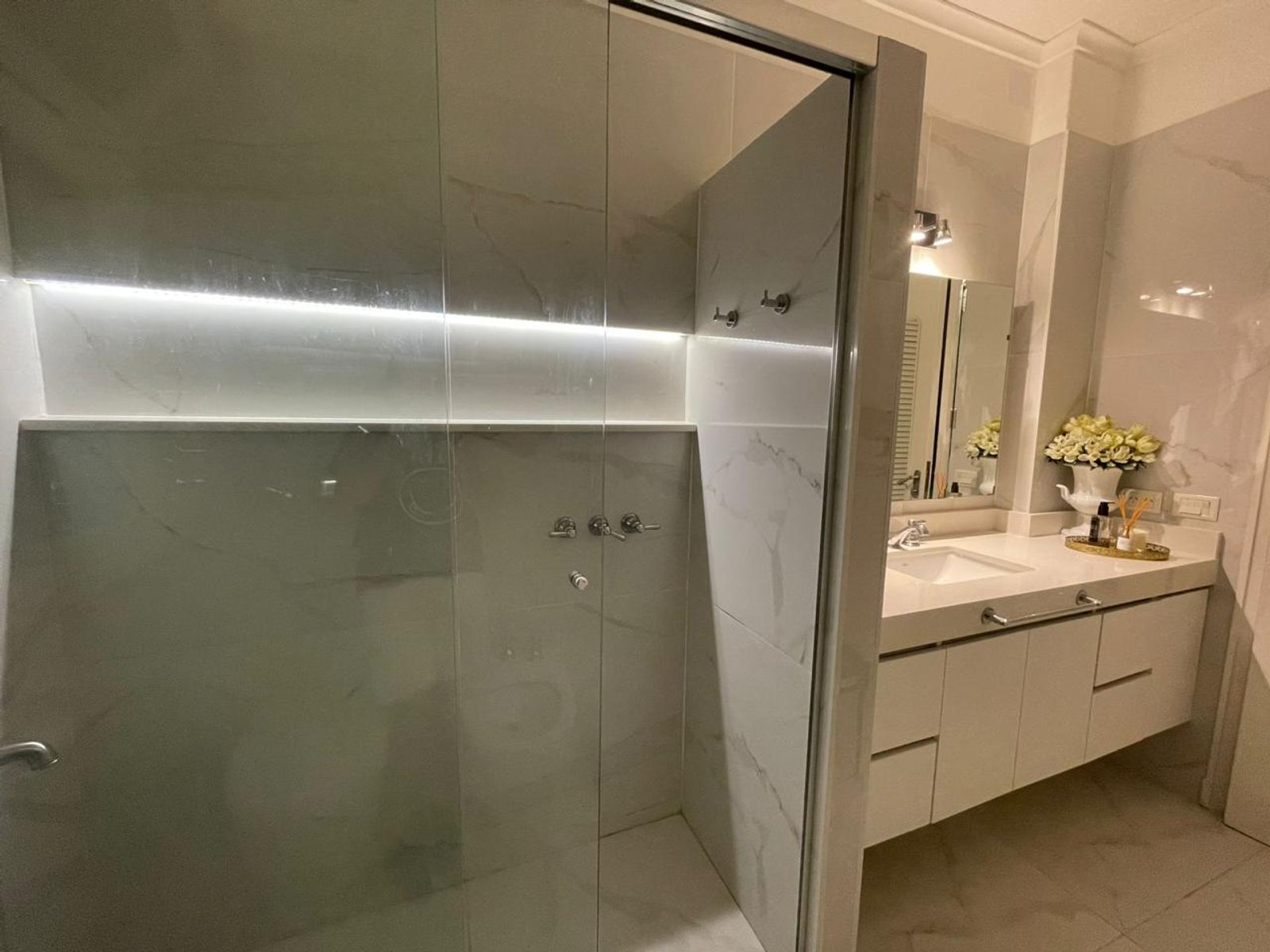 Baño moderno con iluminación integrada y acabados de mármol — proyecto Paraguay , por Estudio NET Arquitectura , en Paraguay 1546